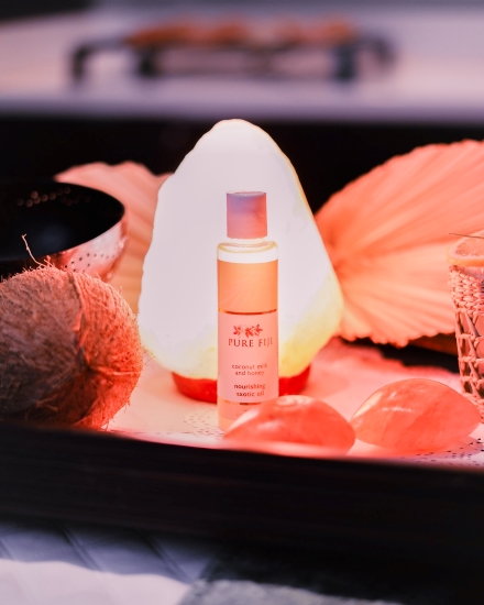 A glowing Himalayan salt rock lamp on a tray with spa oil and a coconut at the Spa at Rosen Centre.