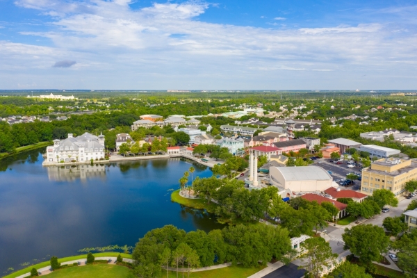 An aerial shot of downtown Celebration, FL, with colorful buildings surrounding a dark blue lake.