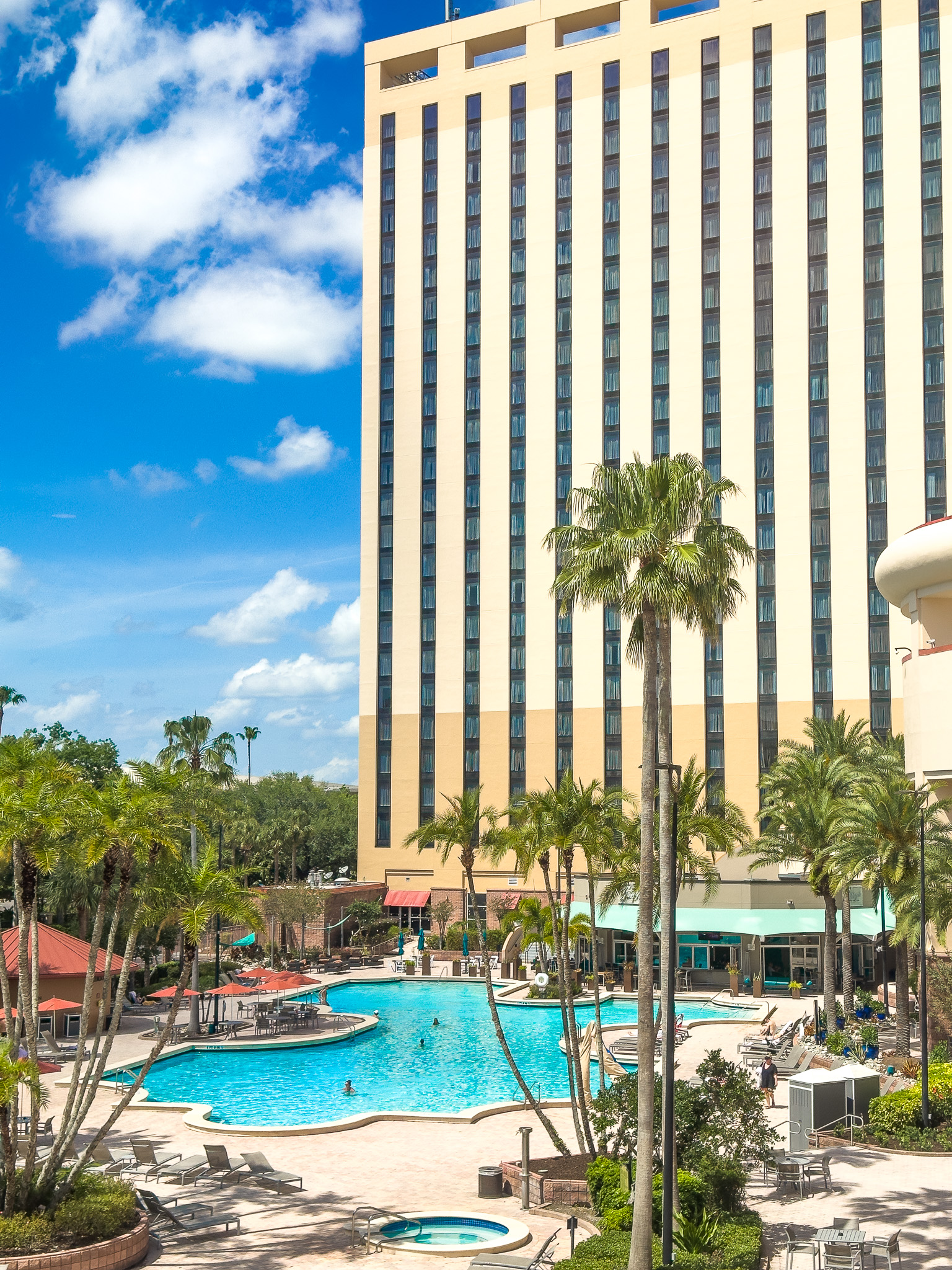 The exterior of Rosen Centre with its blue pool and palm trees, a perfect destination for a wellness trip.