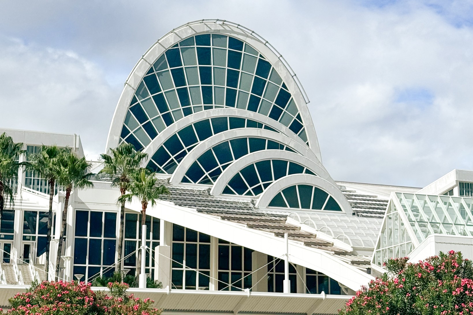 A close-up of the glas sand white arched windows at the entry to the Orange County Convention Center. 