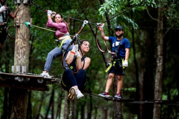 A woman riding a zip line at Orlando Tree Trek Adventure Park.