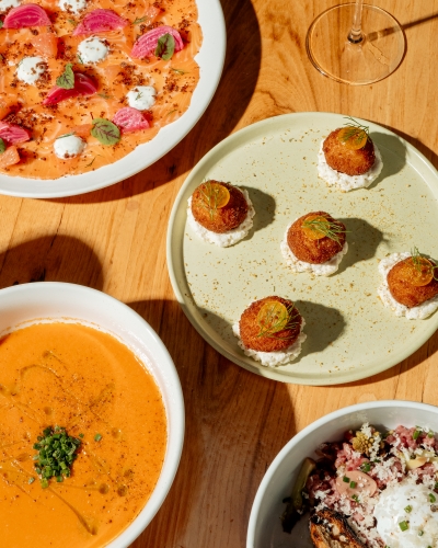 Four rustic Italian dishes set on a wooden table. Prato is a hidden gem restaurant in Orlando..