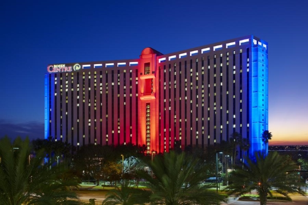 The exterior of Rosen Plaza glowing orange at twilight.