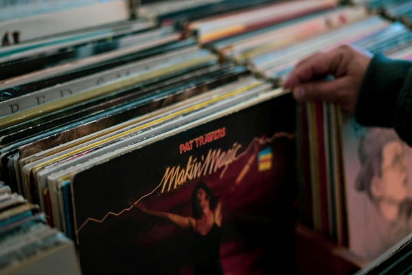 A hand lifts a record of Pat Travers Makin; Magic from a display of records for sale.