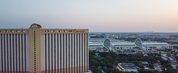 An aerial shot of the side of Rosen Centre at dusk with the OCCC in the distance.