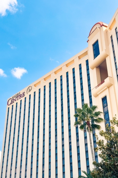 The exterior of Rosen Centre rising up against palm trees and a blue sky.