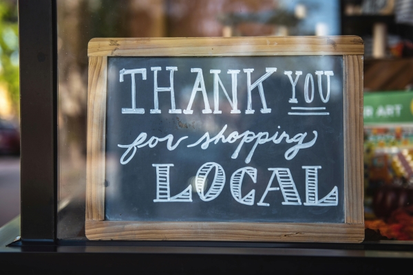 A chalkboard sign in a window that reads Thank you for shopping local. Shop local in Orlando on Small Business Saturday.