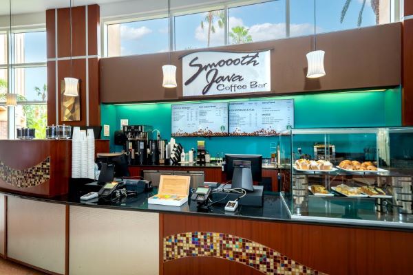 A coffee bar with a sign that reads Smoooth Java and has decorative tile work.