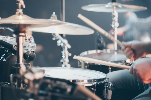 A close-up of hands drumming on a drum set.
